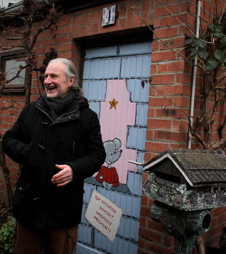 Marc Dubrul, un habitant de la courée Lepers, à Roubaix, devant sa maison. Sa porte est peinte par Françoise Decock, pour protester contre la démolition de son logement.